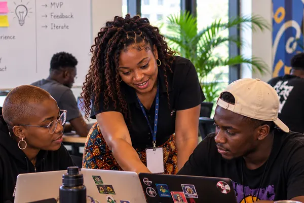 Une formatrice guide un groupe de participants autour de leurs ordinateurs